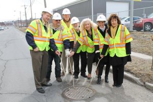 National Water Main Cleaning team after ribbon cutting ceremony opening manhole cover